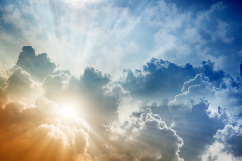 Light from above, bright sun, blue sky and clouds